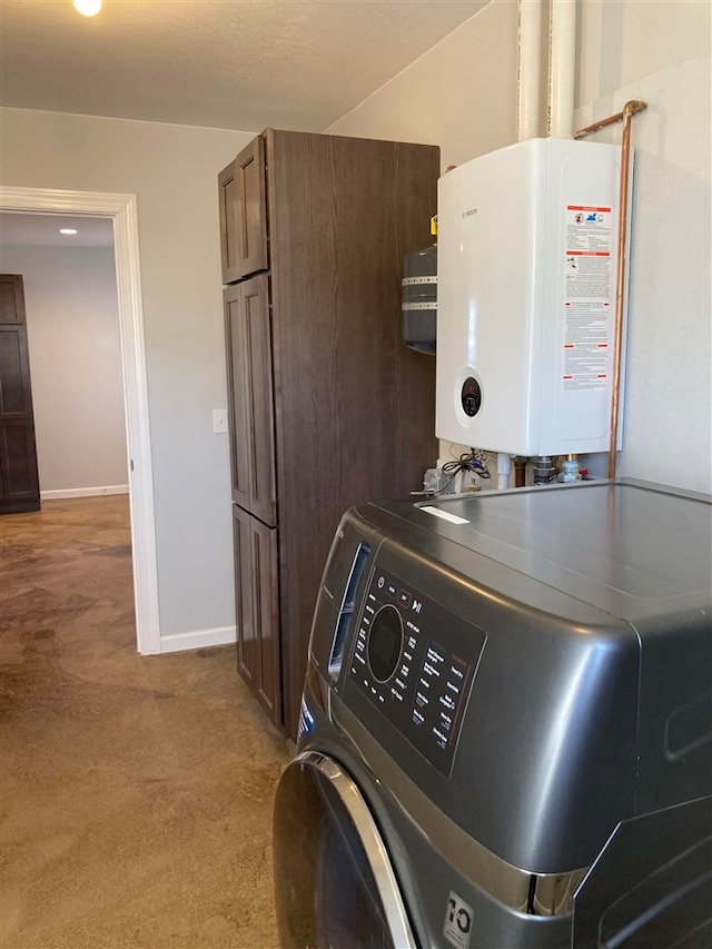 clothes washing area with washer / clothes dryer, light carpet, cabinets, and tankless water heater