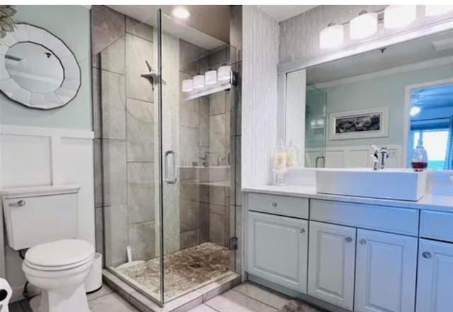 bathroom with walk in shower, toilet, tile floors, and vanity