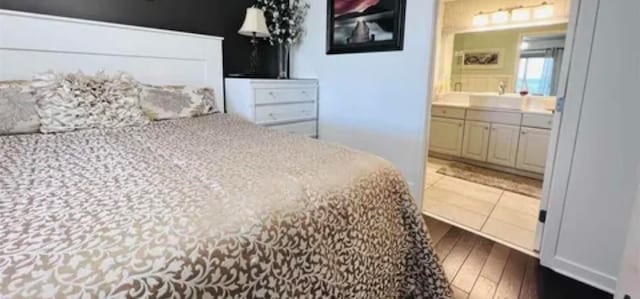 bedroom featuring wood-type flooring and ensuite bath