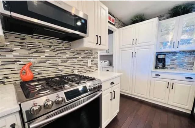 kitchen with appliances with stainless steel finishes, tasteful backsplash, white cabinetry, and dark wood-type flooring