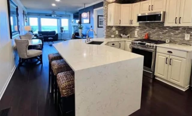 kitchen featuring sink, appliances with stainless steel finishes, tasteful backsplash, and kitchen peninsula