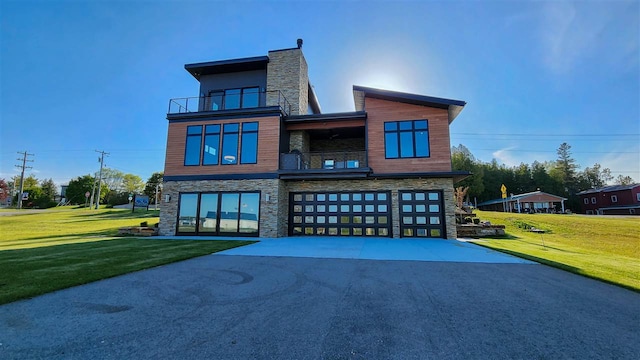 contemporary home with a garage, a balcony, and a front yard