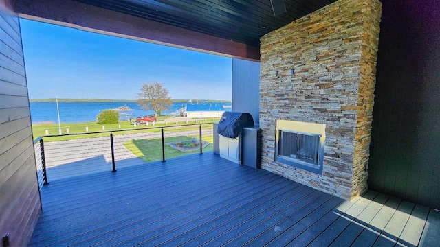 wooden terrace with grilling area and a water view