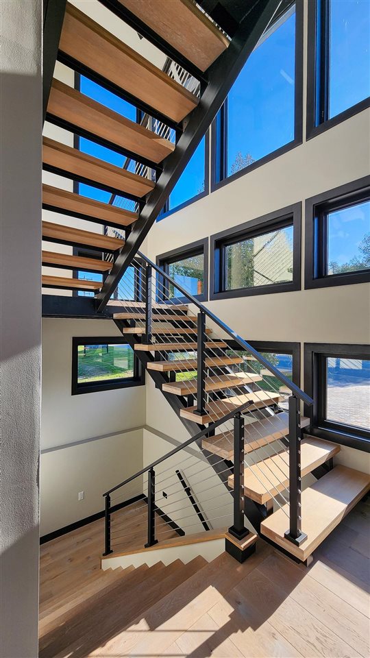 staircase with a high ceiling and hardwood / wood-style flooring