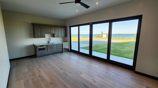 interior space featuring a water view, sink, and light wood-type flooring