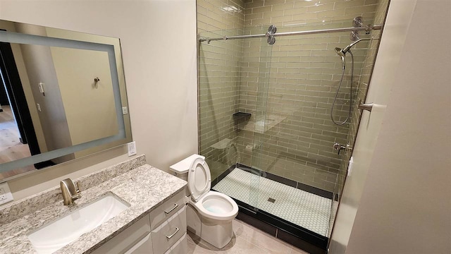 bathroom featuring vanity, tiled shower, tile patterned flooring, and toilet