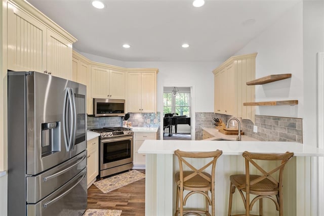 kitchen featuring sink, backsplash, kitchen peninsula, and stainless steel appliances