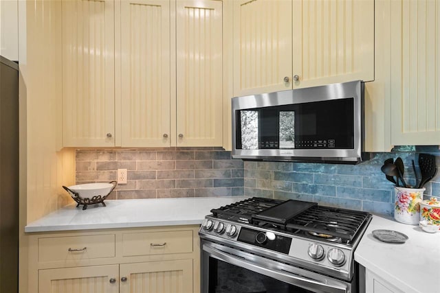 kitchen featuring backsplash, cream cabinets, and appliances with stainless steel finishes