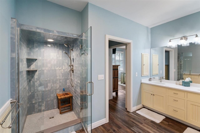 bathroom featuring dual vanity, walk in shower, and wood-type flooring