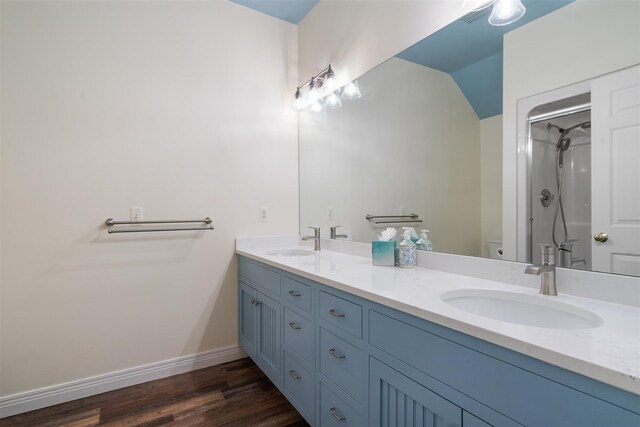 bathroom with walk in shower, toilet, hardwood / wood-style flooring, and double sink vanity