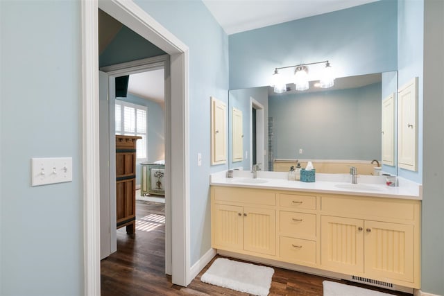 bathroom with dual vanity and hardwood / wood-style floors