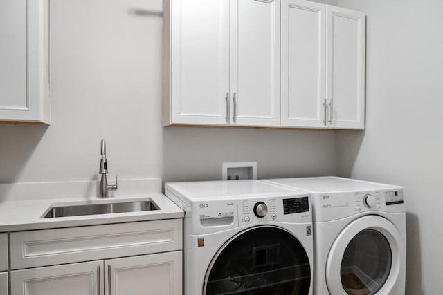 laundry room with cabinets, separate washer and dryer, and sink