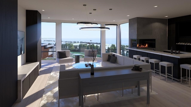 dining room featuring expansive windows, a tiled fireplace, and light hardwood / wood-style flooring