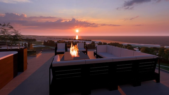 patio terrace at dusk with an outdoor living space with a fire pit and a water view