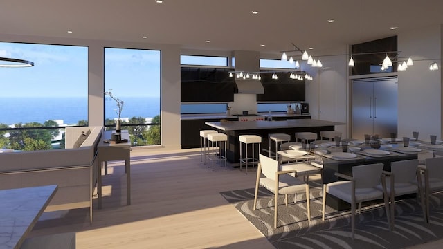 dining room featuring light wood-type flooring and a water view