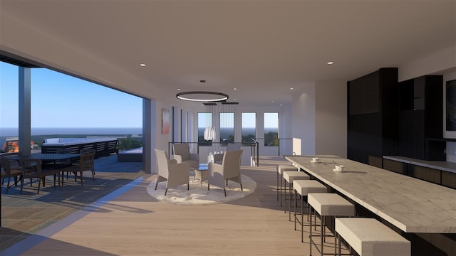 dining area with french doors, light wood-type flooring, and a water view