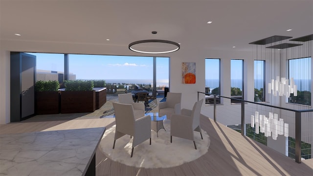 dining space with light hardwood / wood-style floors, a water view, and a healthy amount of sunlight