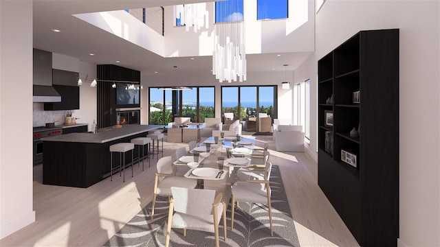 dining room featuring a high ceiling, sink, and light wood-type flooring