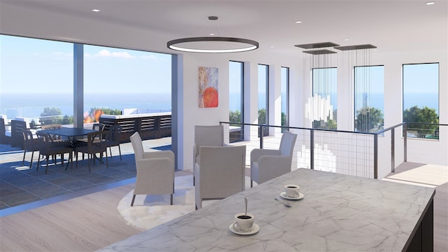 dining space featuring a water view and hardwood / wood-style flooring