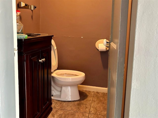 bathroom featuring tile flooring, vanity, and toilet