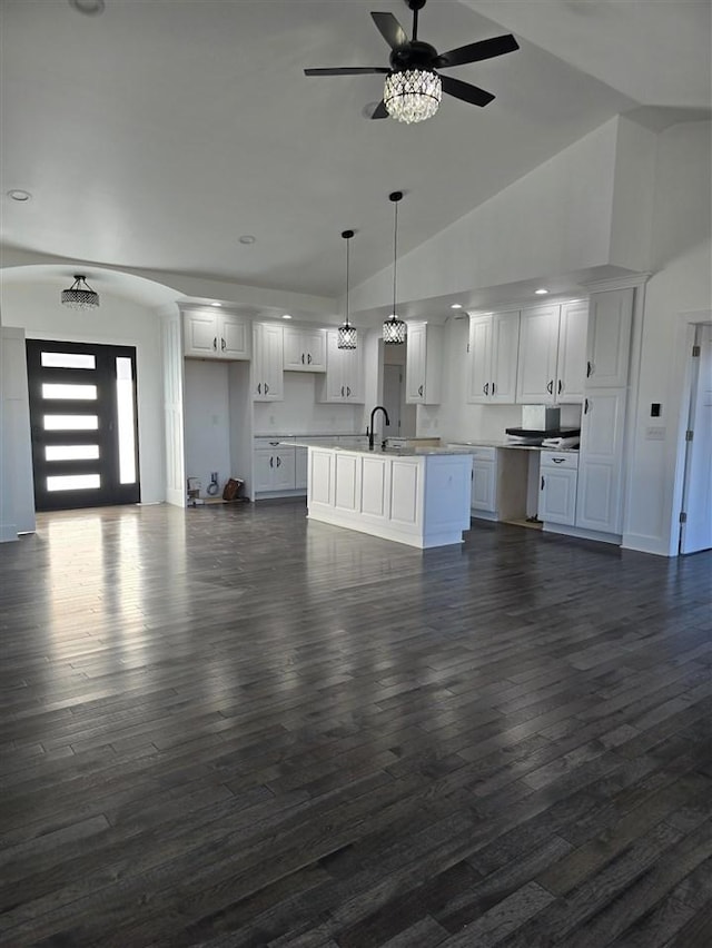 unfurnished living room featuring ceiling fan, dark hardwood / wood-style flooring, sink, and high vaulted ceiling