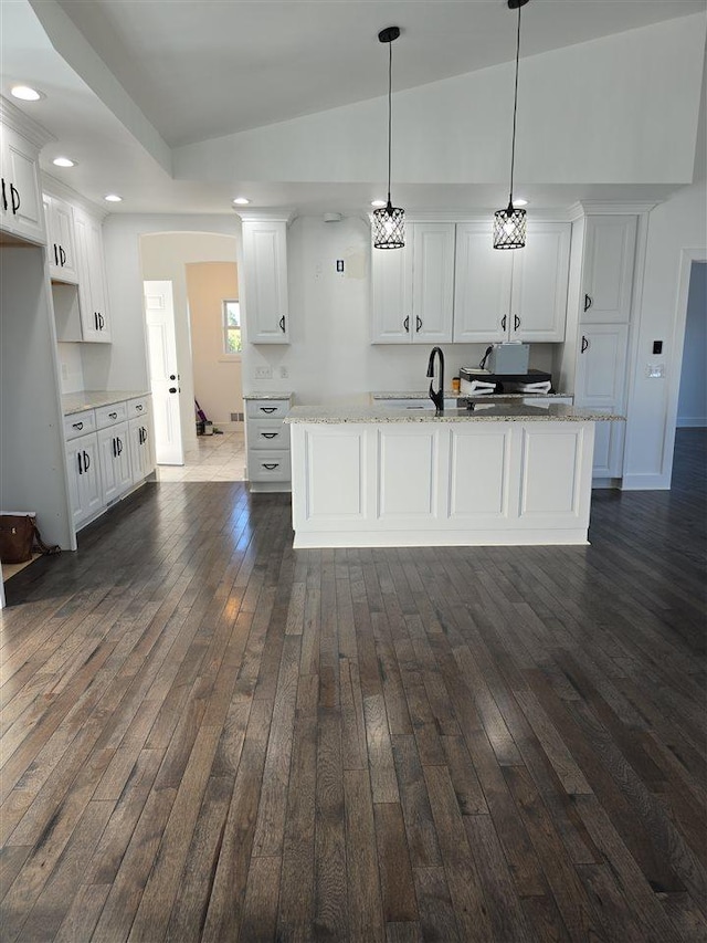 kitchen featuring white cabinets, hanging light fixtures, and dark wood-type flooring