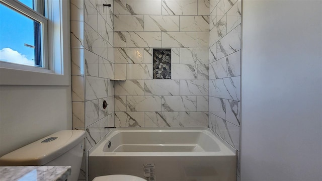 bathroom with tiled shower / bath combo and toilet