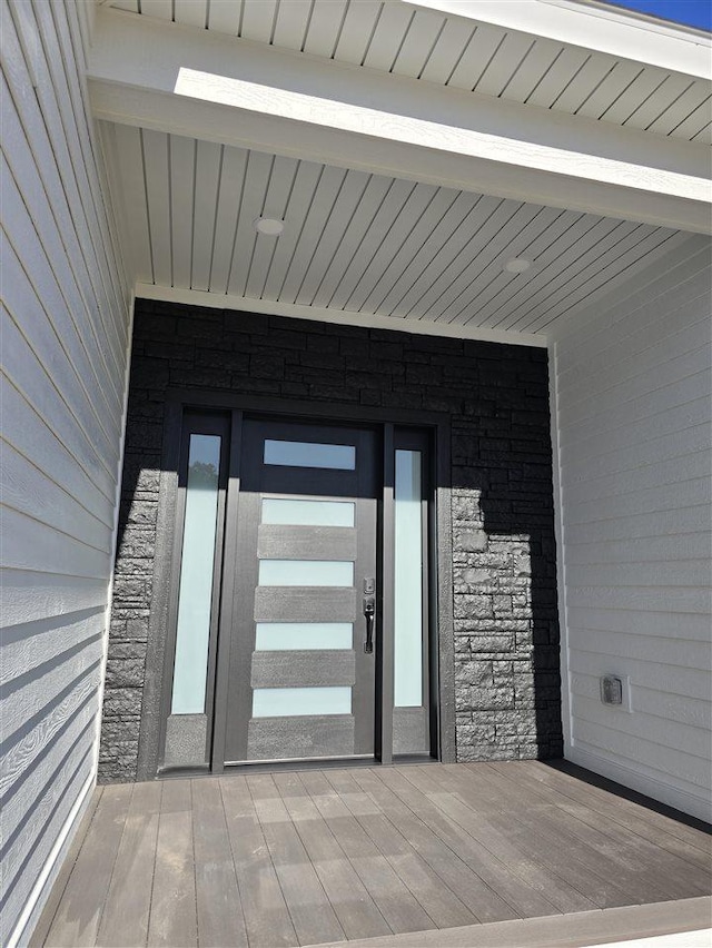 exterior space with light hardwood / wood-style flooring and beamed ceiling