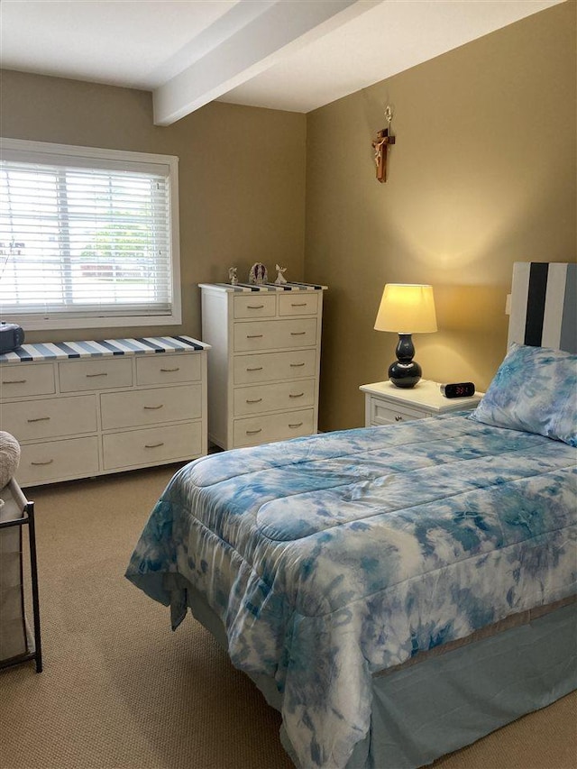 bedroom featuring beam ceiling and light colored carpet