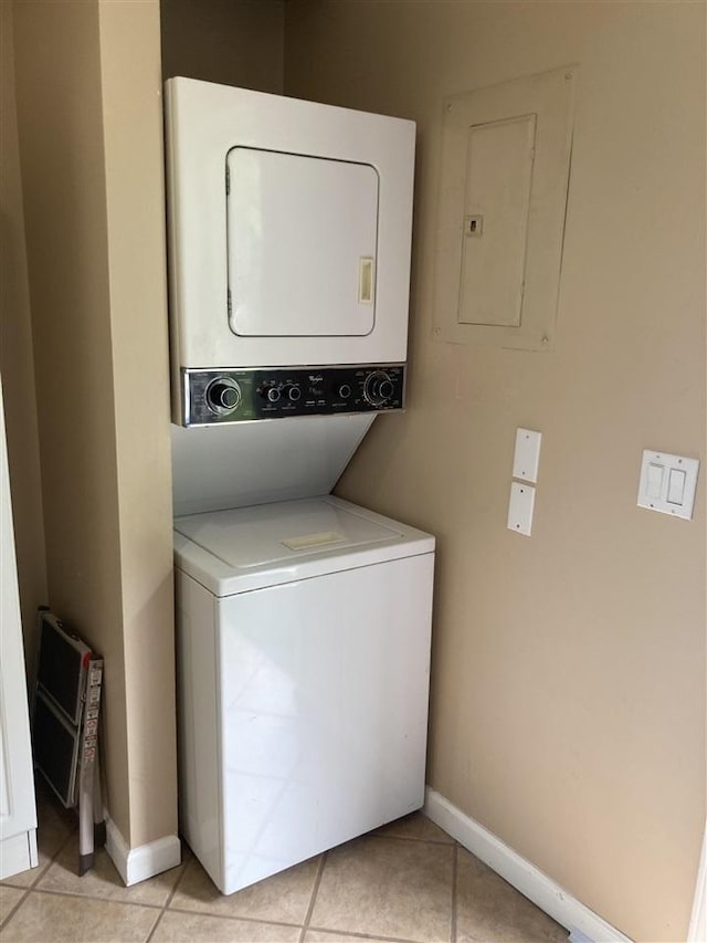 laundry area with light tile patterned flooring, stacked washer and dryer, and electric panel