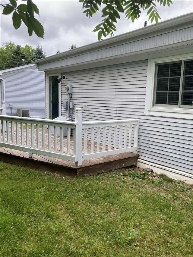 wooden terrace featuring a lawn