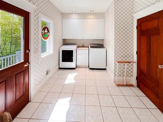 clothes washing area with cabinets, sink, independent washer and dryer, and light tile floors