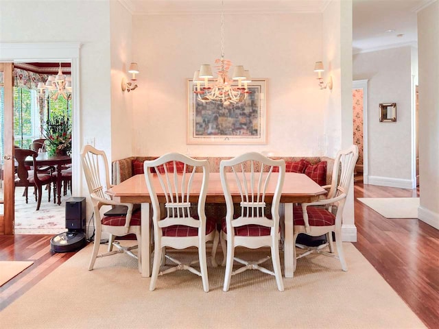 dining room with ornamental molding, an inviting chandelier, and wood-type flooring