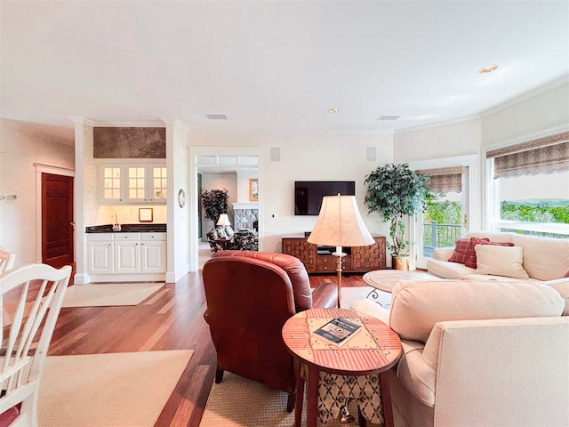 living room with light hardwood / wood-style flooring and crown molding