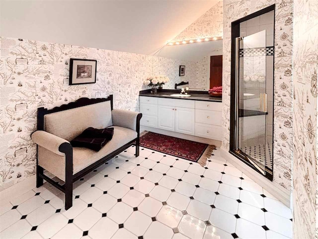 bathroom with tile floors, lofted ceiling, large vanity, and a tile shower