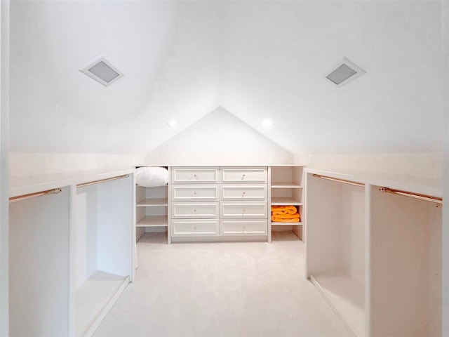 spacious closet featuring vaulted ceiling and light colored carpet