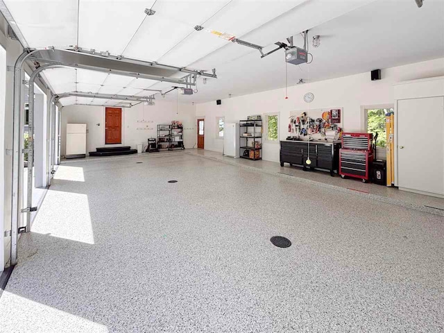 garage with a garage door opener and white fridge