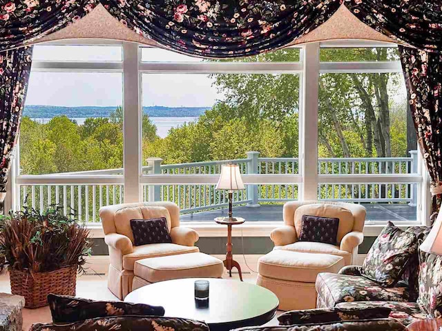 sunroom / solarium featuring a wealth of natural light and a water view