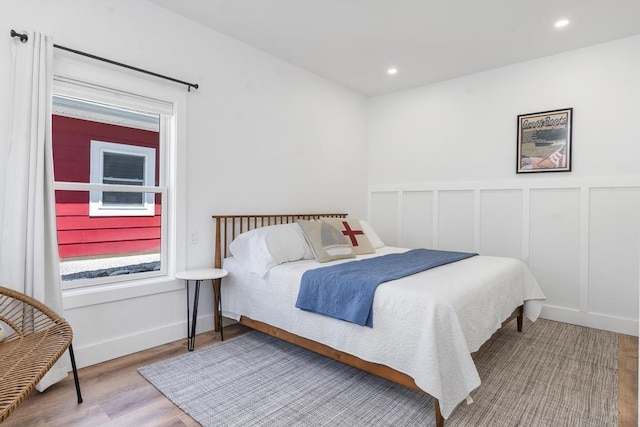 401 Antrim St, Charlevoix, MI 49720 - bedroom featuring wood finished floors, recessed lighting, wainscoting, and a decorative wall