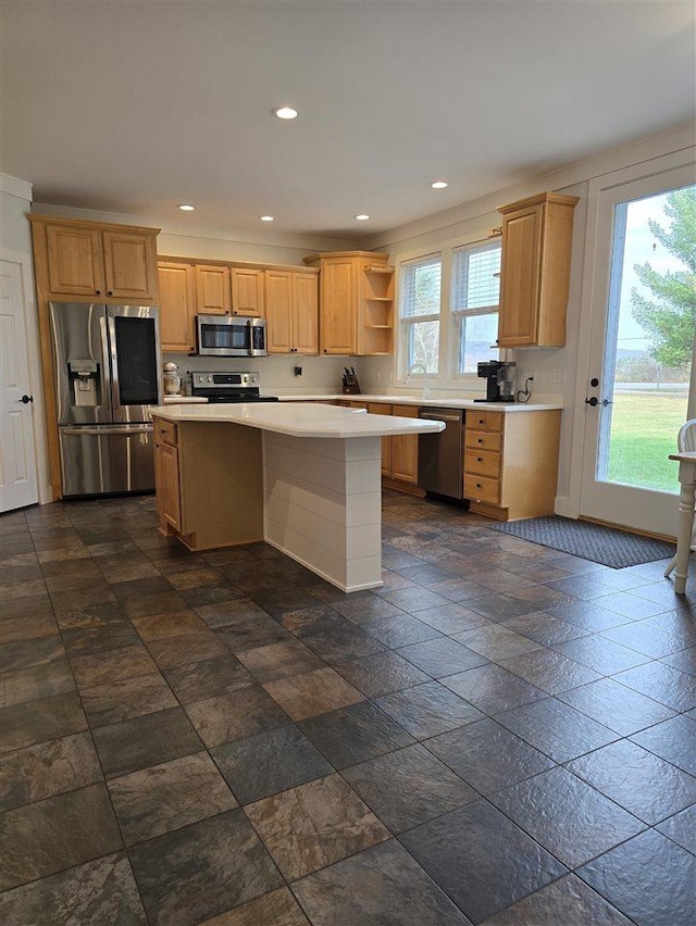 kitchen featuring appliances with stainless steel finishes, a breakfast bar, a kitchen island, and light brown cabinets