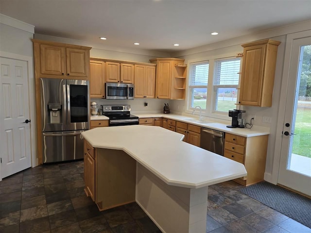 kitchen with light brown cabinetry, sink, stainless steel appliances, and a kitchen island