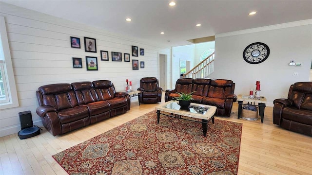 living room featuring ornamental molding, light hardwood / wood-style floors, and a wealth of natural light