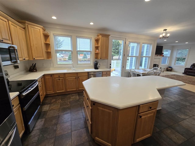 kitchen featuring appliances with stainless steel finishes, a wealth of natural light, sink, hanging light fixtures, and a center island