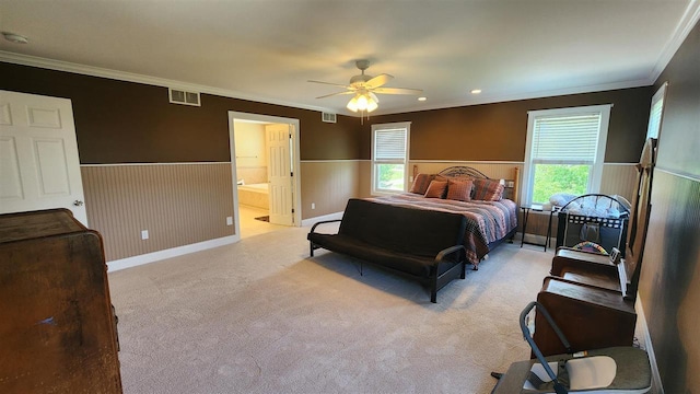 carpeted bedroom featuring crown molding, ensuite bathroom, and ceiling fan