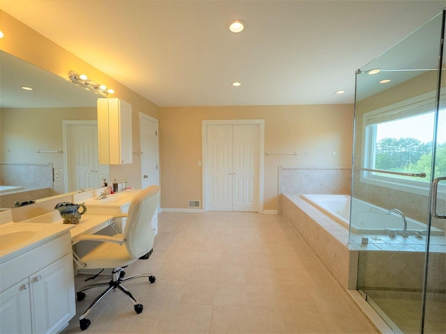 bathroom with vanity and tiled tub