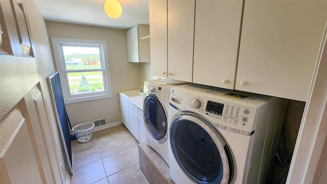 clothes washing area featuring cabinets, light tile patterned flooring, sink, and washer and clothes dryer