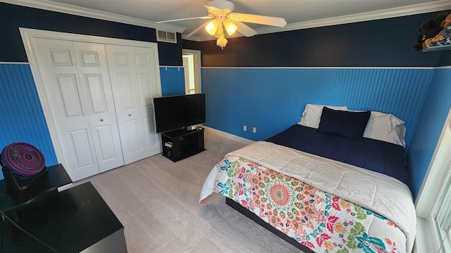 bedroom with ornamental molding, carpet flooring, ceiling fan, and a closet