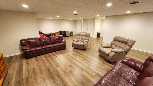 living room with a drop ceiling and hardwood / wood-style floors