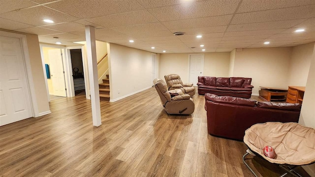 living room with hardwood / wood-style floors and a drop ceiling