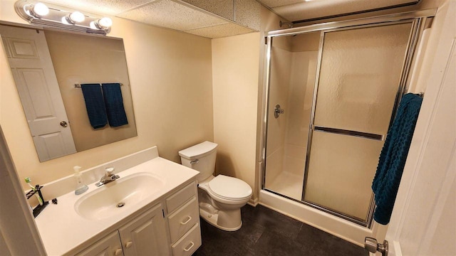 bathroom featuring vanity, toilet, an enclosed shower, and a drop ceiling